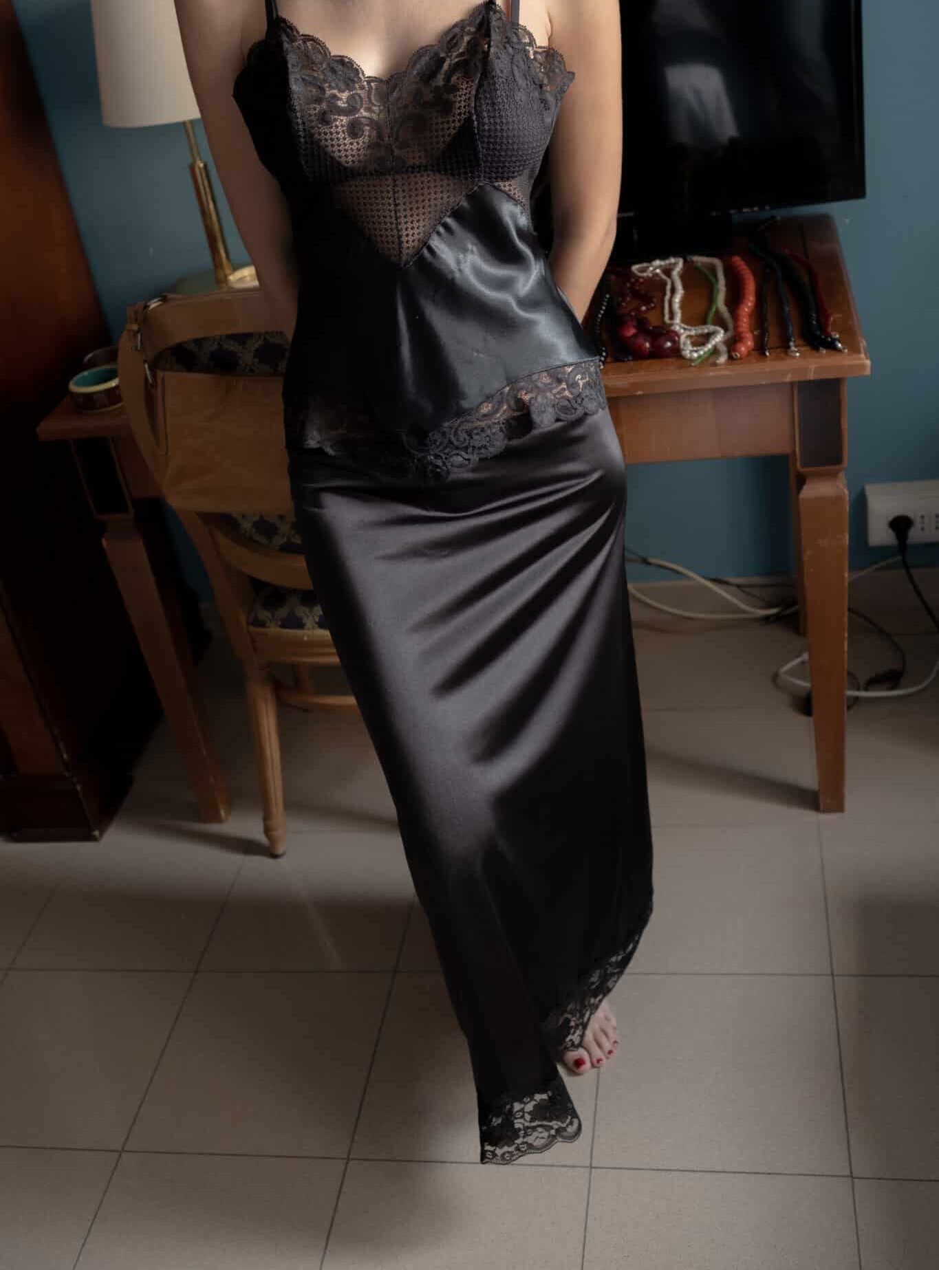 Black satin slip dress with lace bodice and lace-trimmed hem