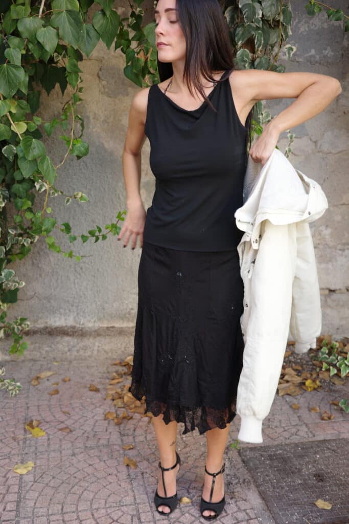 Black boat neck tank top with wide neckline and fitted silhouette.