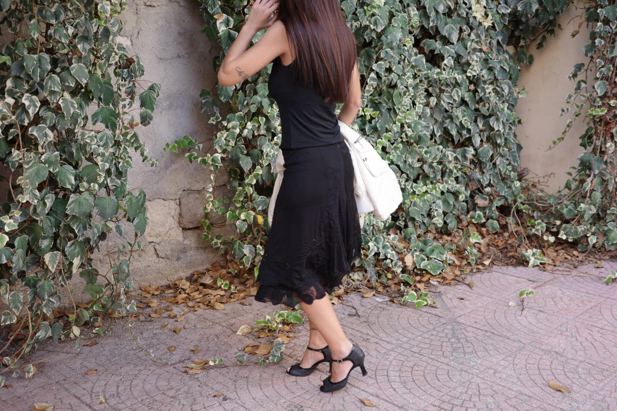 Black top and skirt styled under a long cream parka with zipper front.