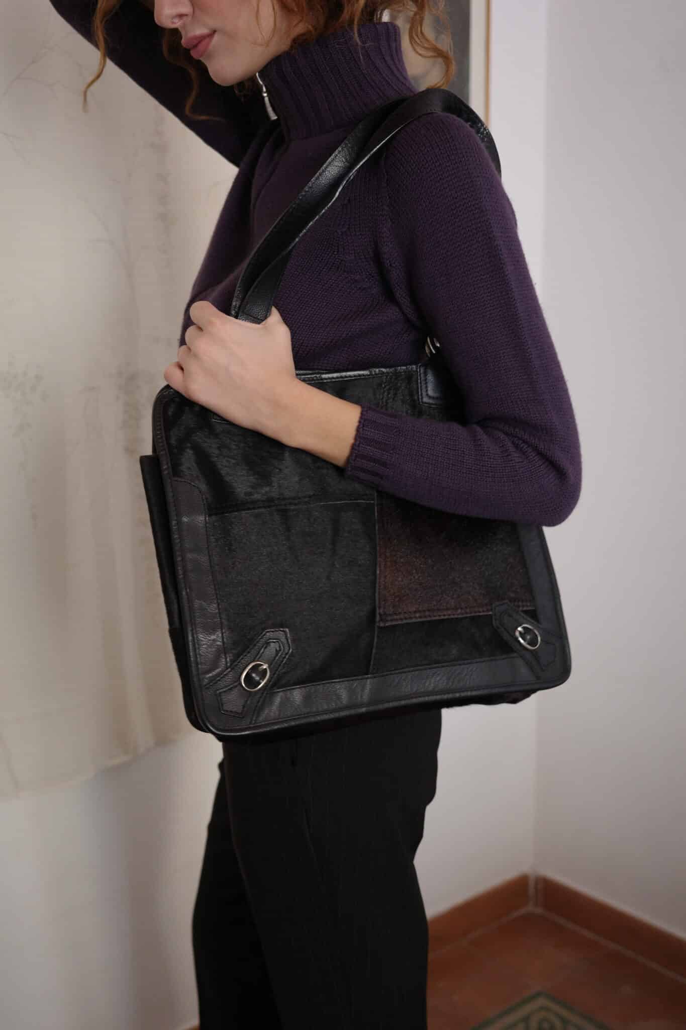 Medium-sized brown leather bag with curved edges and top-zip closure