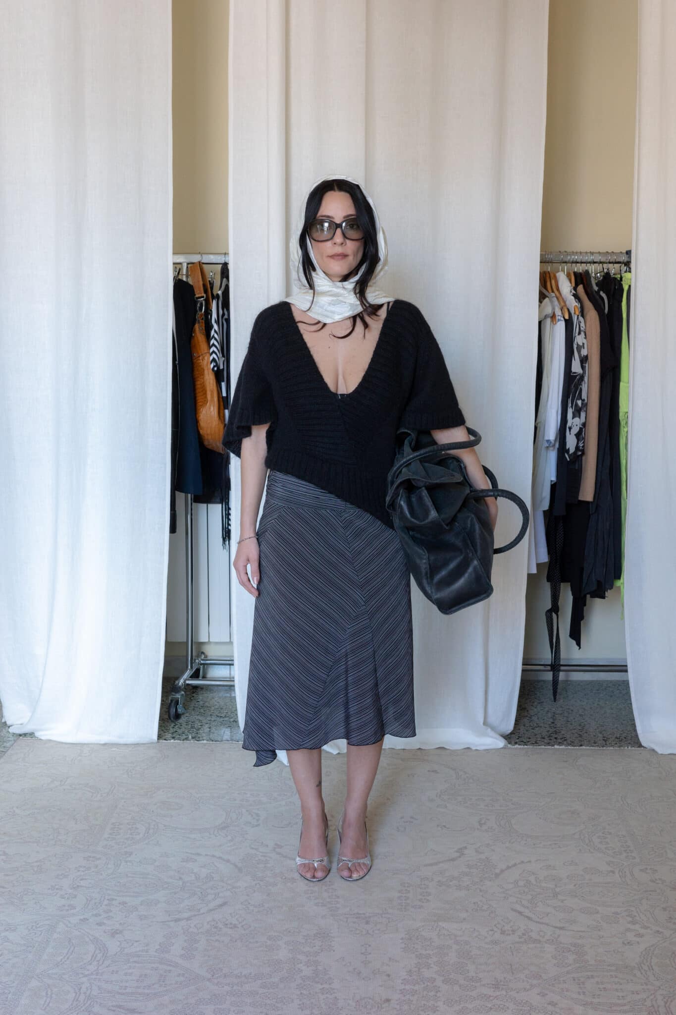 Deep v-cut mohair blend sweater styled with black and white asymmetrical midi skirt, cream silk scarf and large leather bag