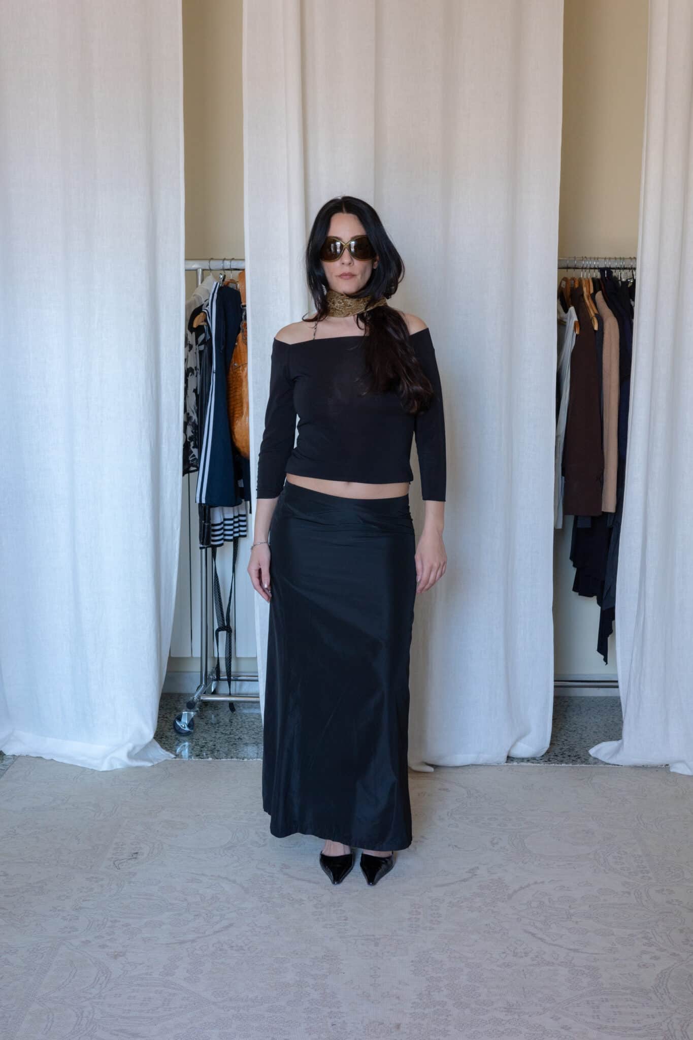 Black off shoulder top styled with a black satin maxi skirt, pointed heels and printed neck scarf