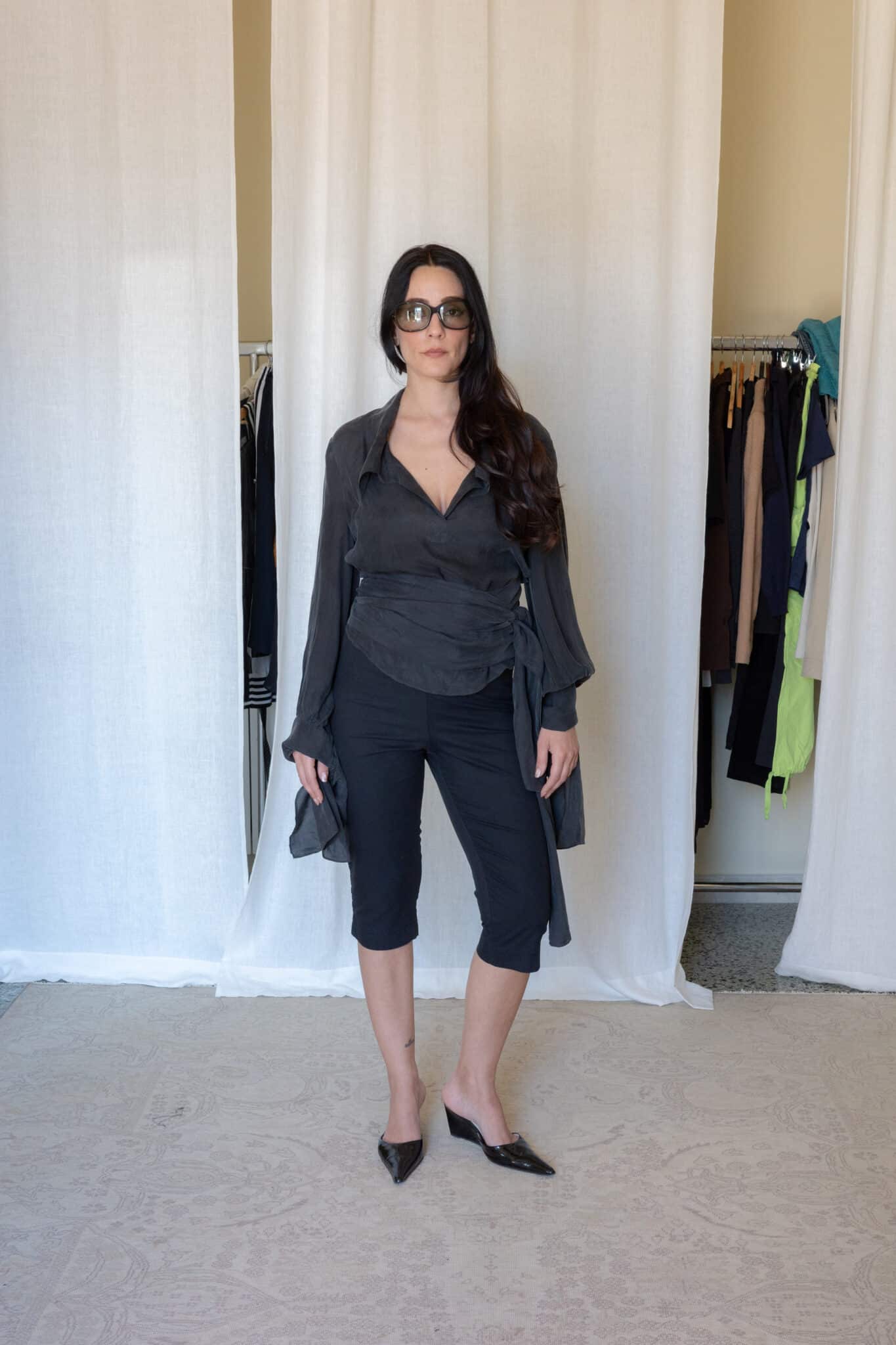 Charcoal sheer wrap top with tie waist detailing styled with fitted black capri pants and pointed mule heels