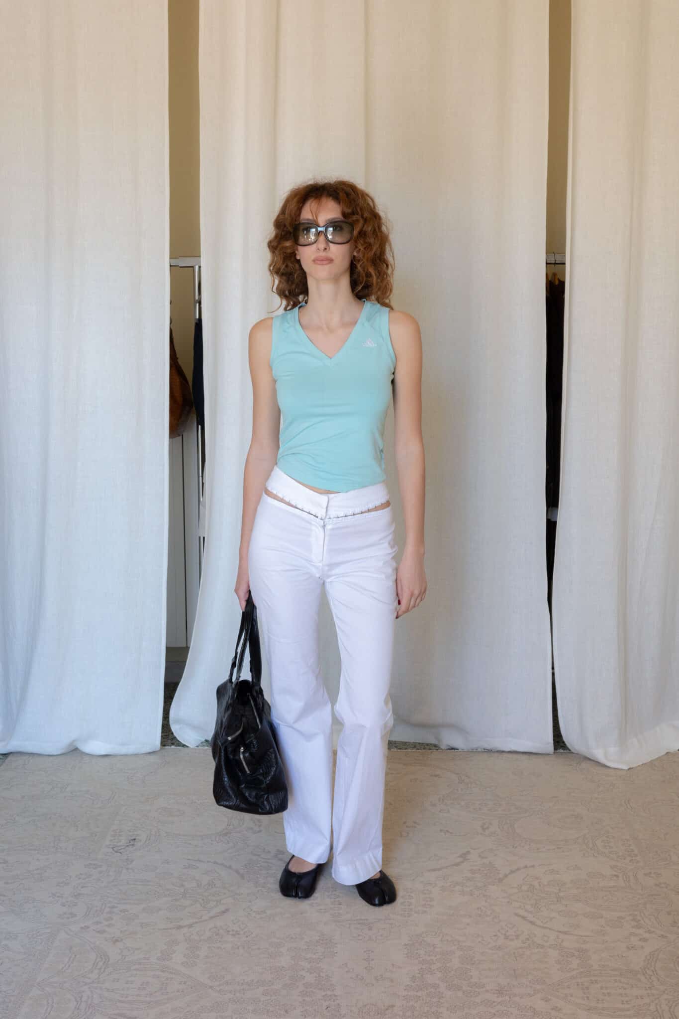 Side view of a fitted light blue Adidas tank top with clean seam detailing, soft stretch construction and a sleek sleeveless silhouette with a subtle v-neck shape.