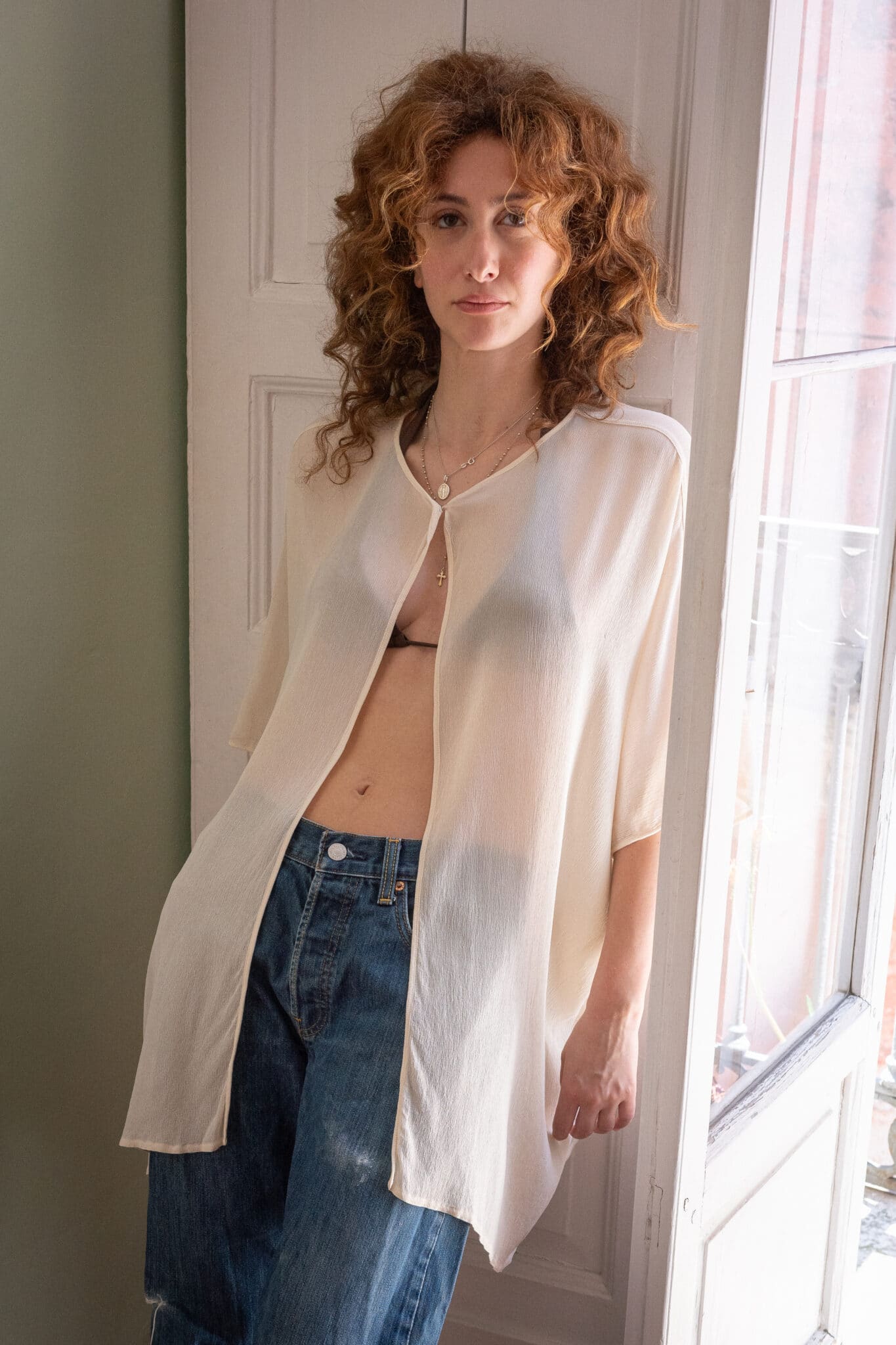 Sheer cream silk cocoon top featuring a fluid oversized silhouette, wide sleeves, and lightweight semi-transparent fabric.