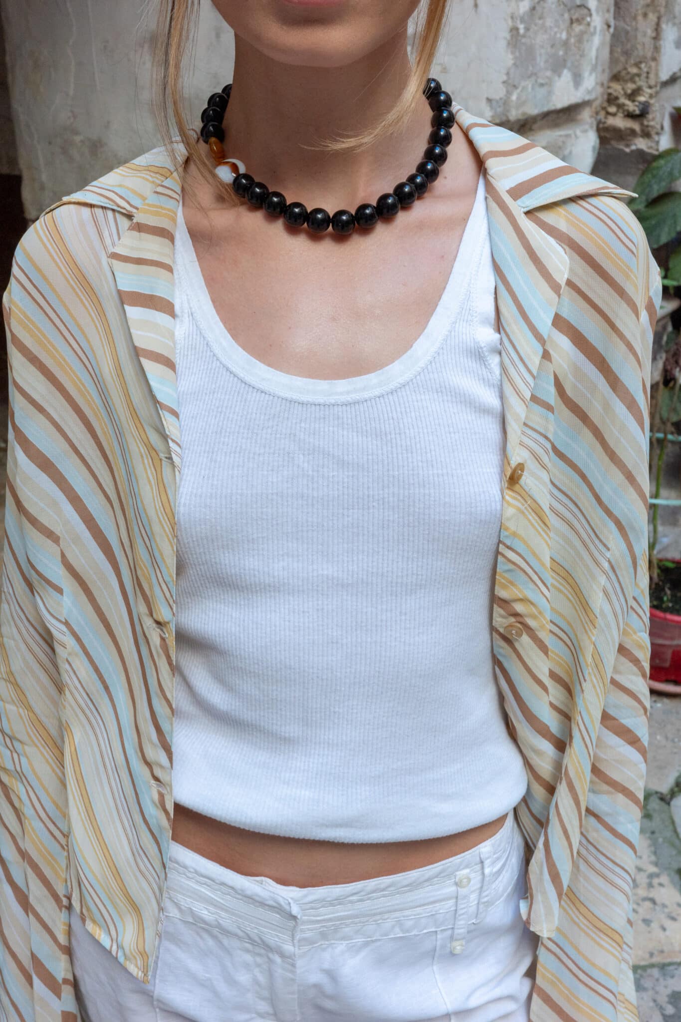 High-waisted white trousers with straight wide legs.