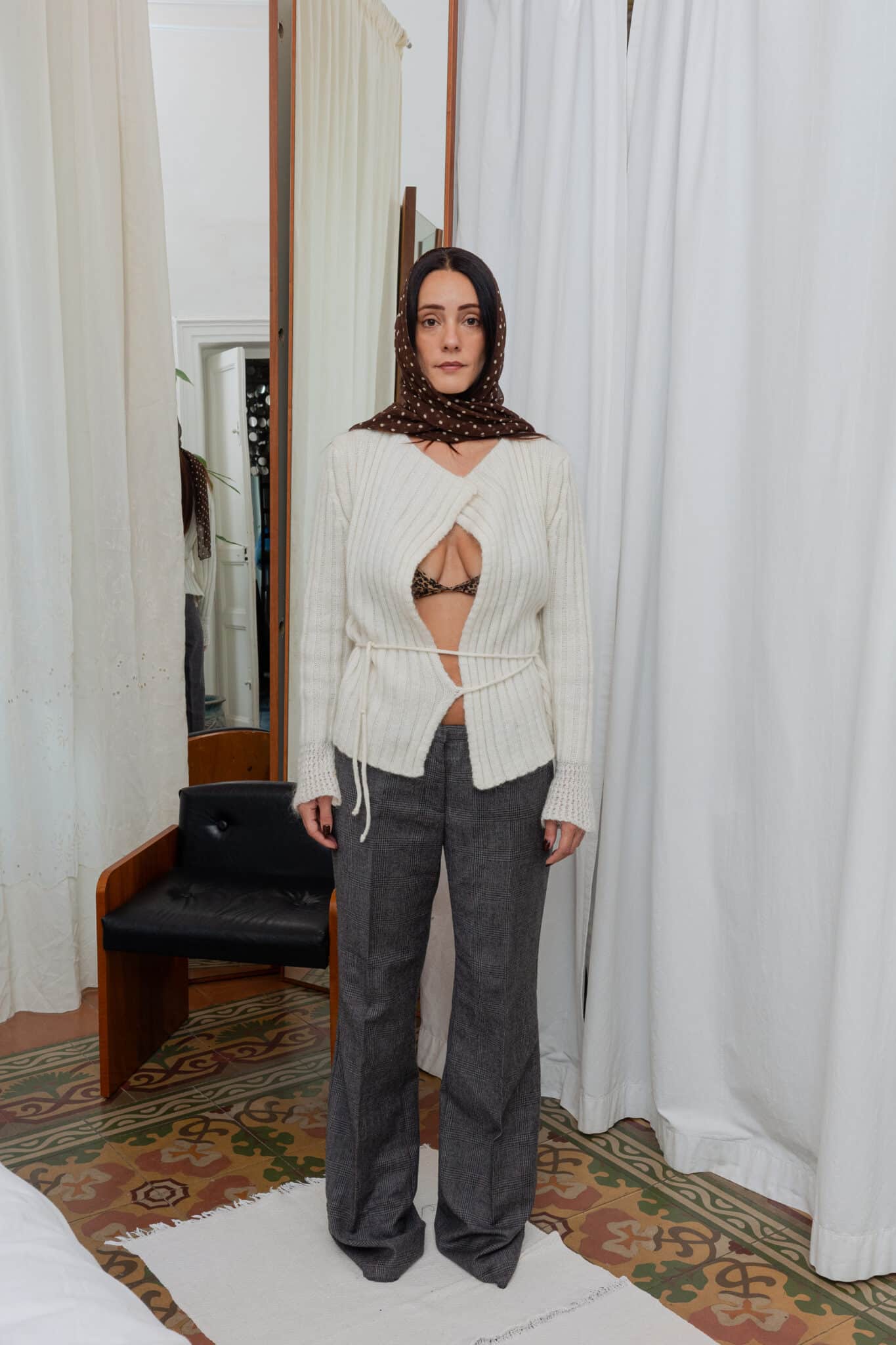 Full outfit featuring cream ribbed cardigan, grey check trousers and brown polka scarf in natural light.