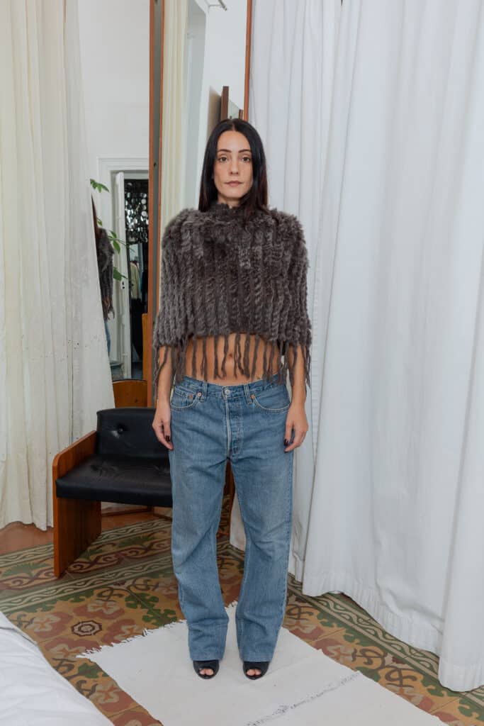 Outfit photographed in natural light showing cropped fur top and Levi’s straight-leg jeans.