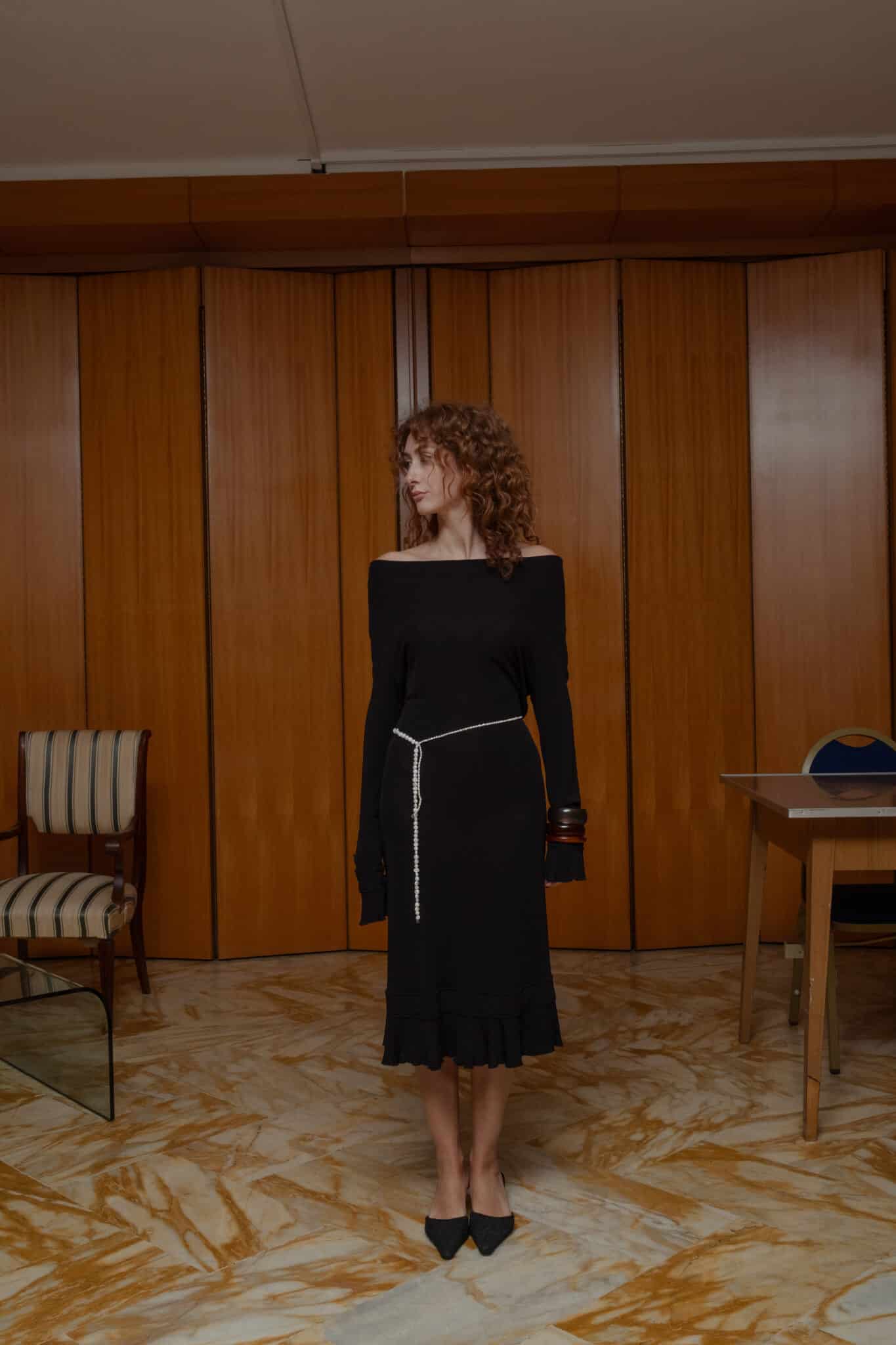 Black midi dress featuring an off-shoulder neckline and long sleeves