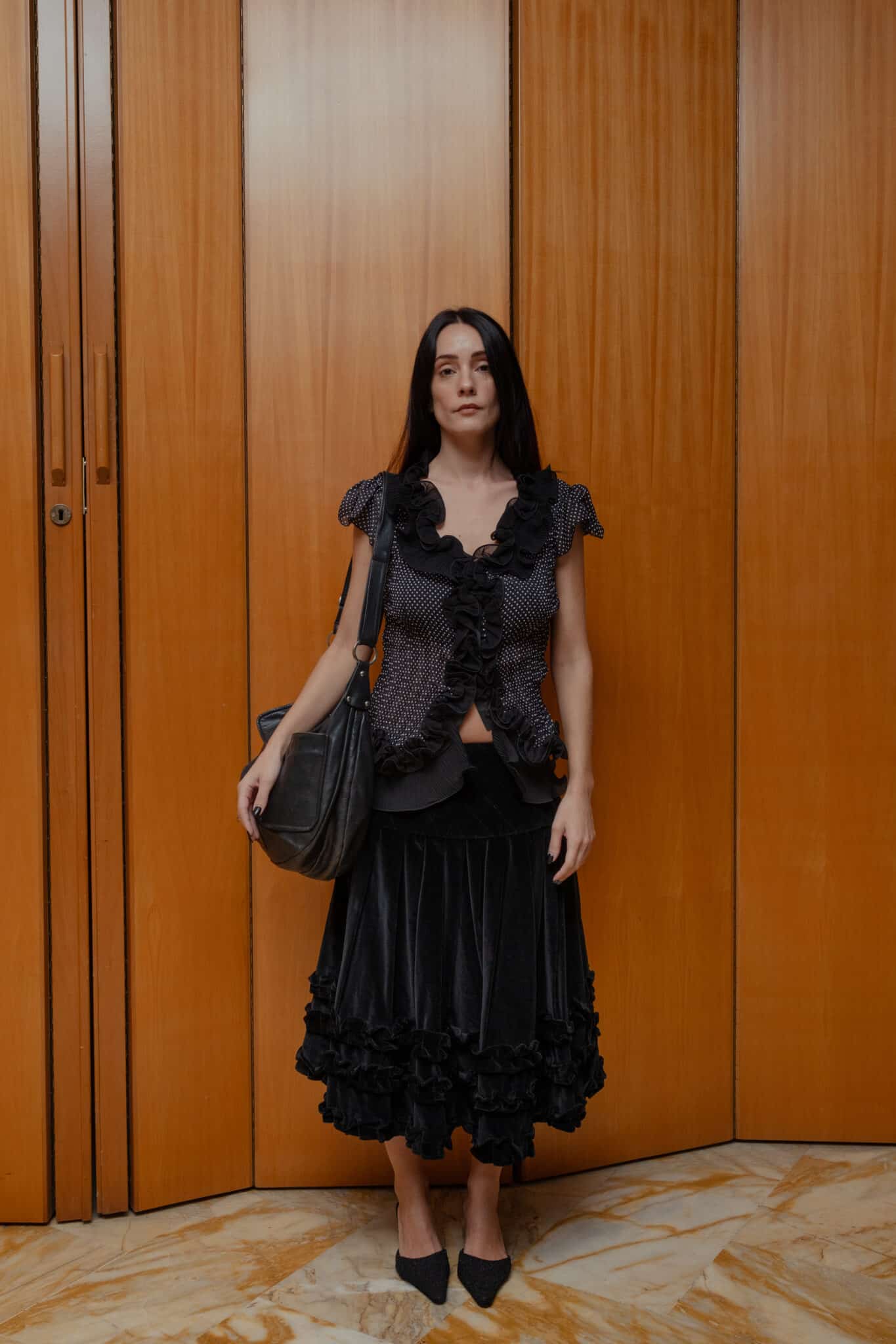 Black feminine outfit with ruffle details and midi-length skirt