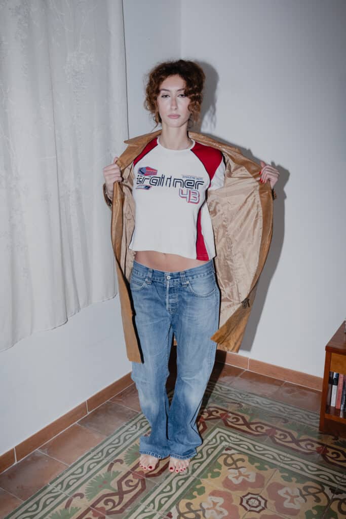 Layered look with a long leather coat, printed long-sleeve, and classic Levis bootcut jeans.