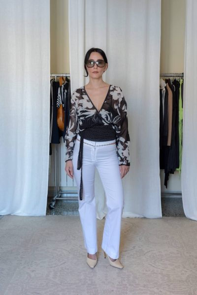 Black sheer floral wrap top with long sleeves styled with white tailored trousers and beige heels, women’s fitted outfit