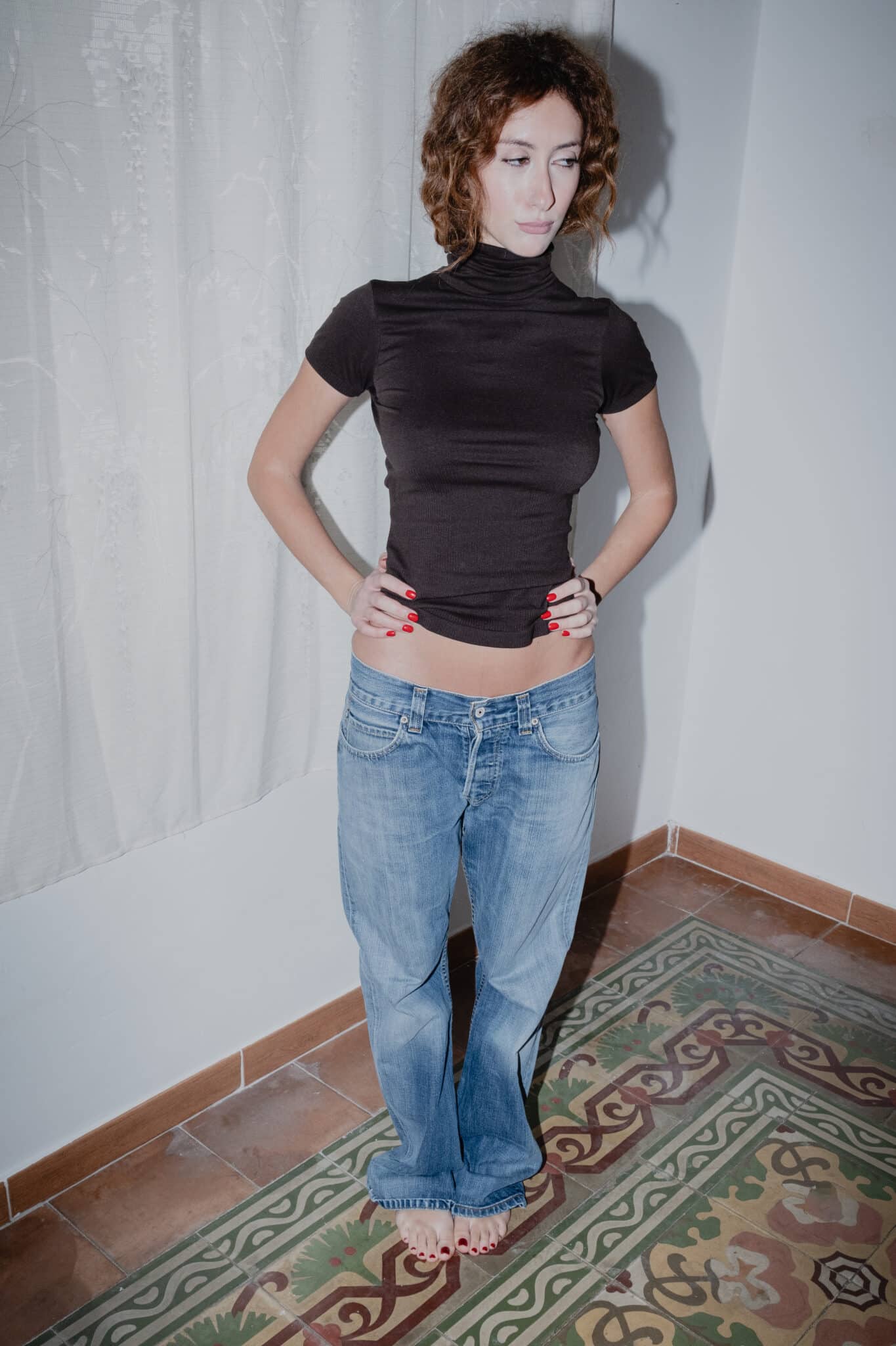 front view of a black short-sleeve turtleneck top with classic bootcut Levi’s jeans