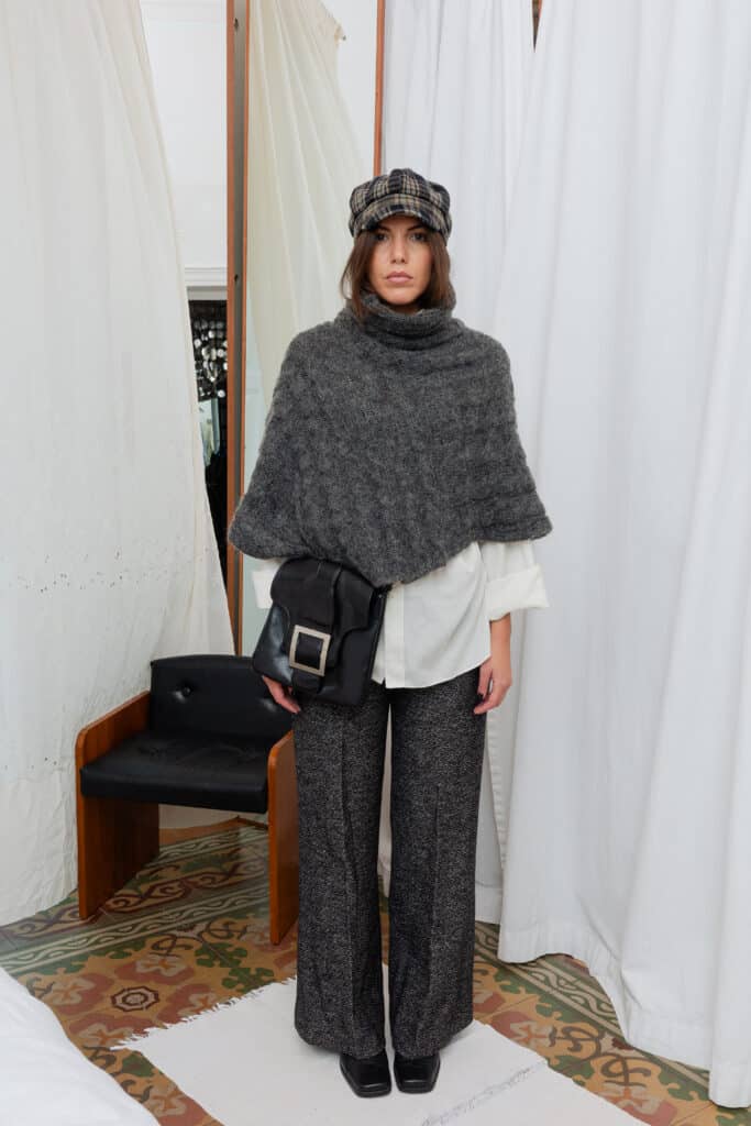 Front view of grey cable knit cape with visible cable detailing and soft drape.