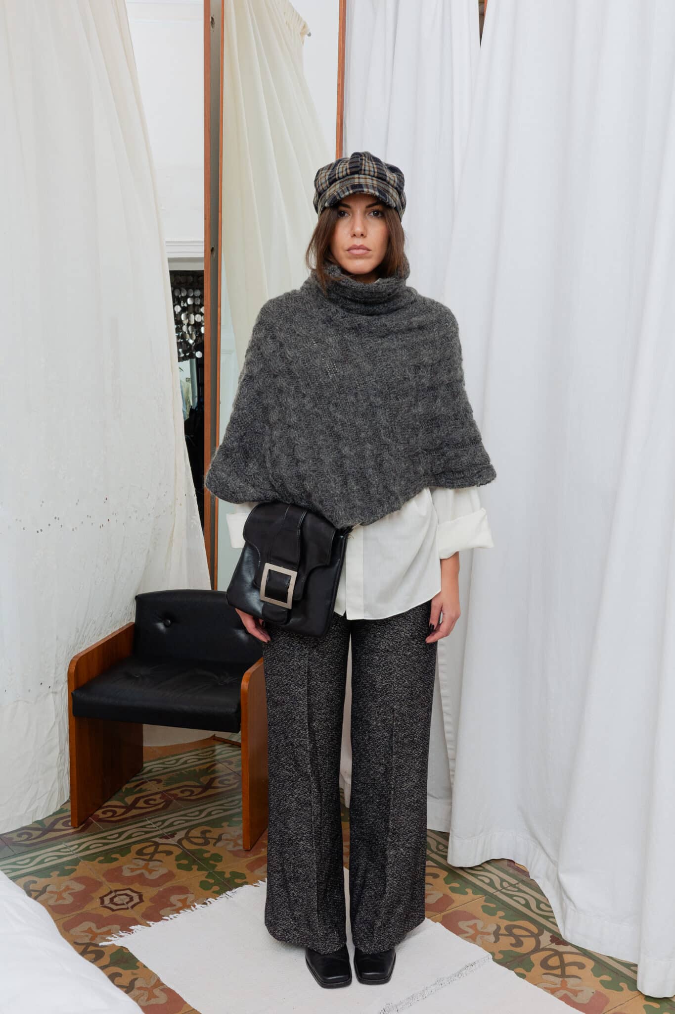 Front view of grey cable knit cape with visible cable detailing and soft drape.