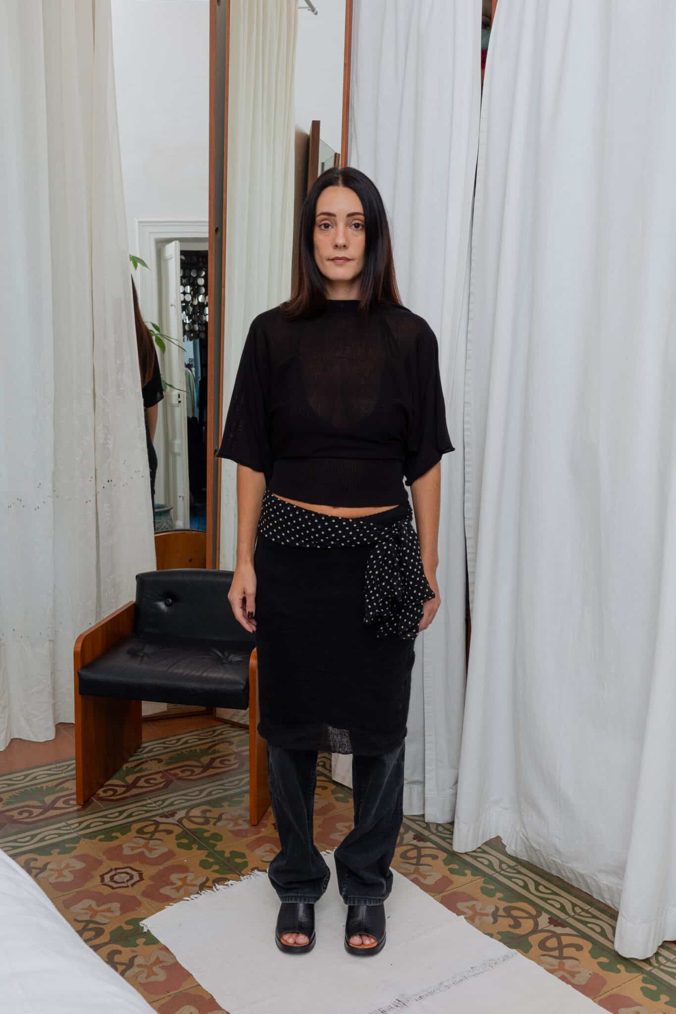 Full outfit featuring sheer black top, black textured skirt, and polka dot scarf detail.