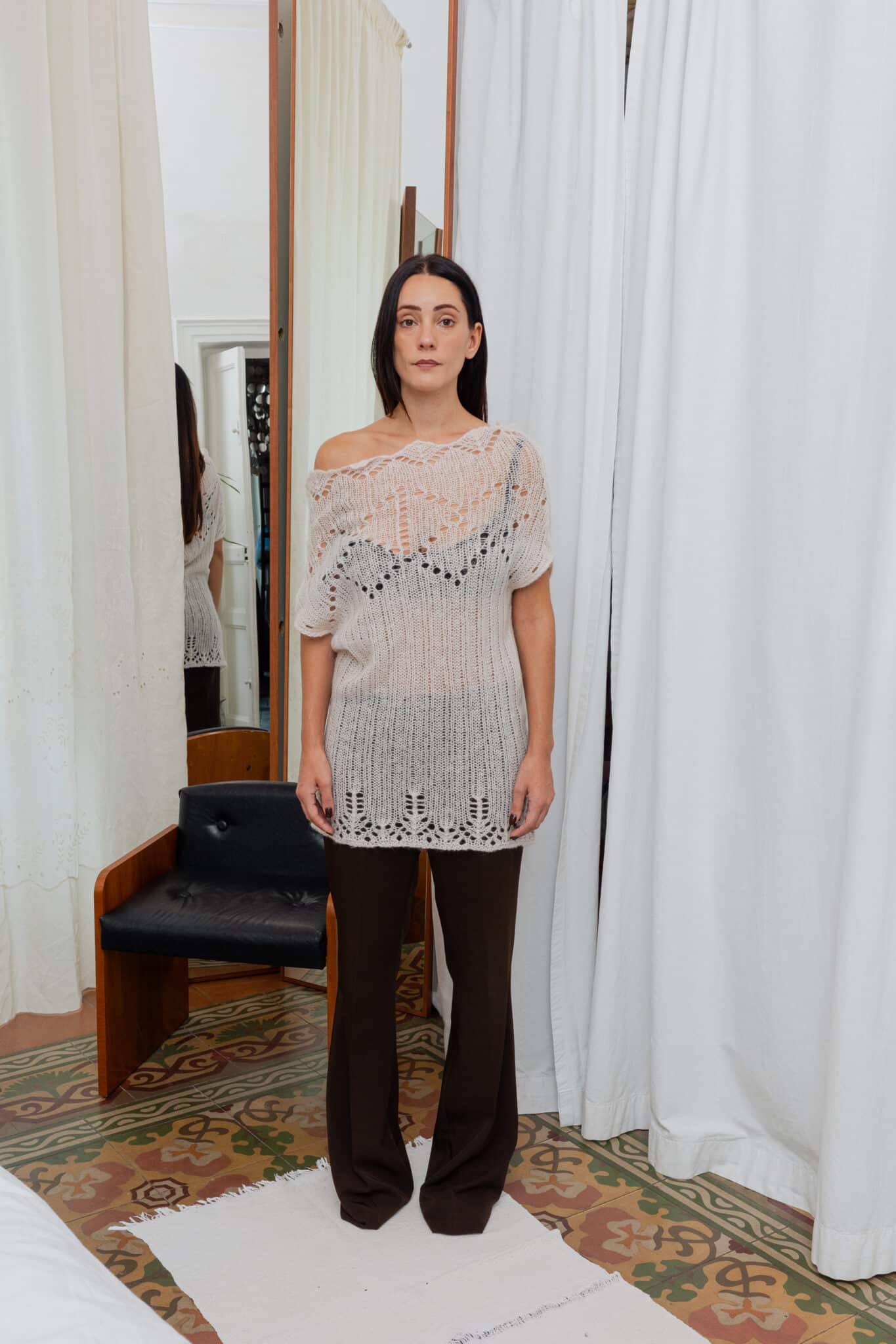 Full outfit featuring long denim trench coat over crochet knit top and brown trousers.