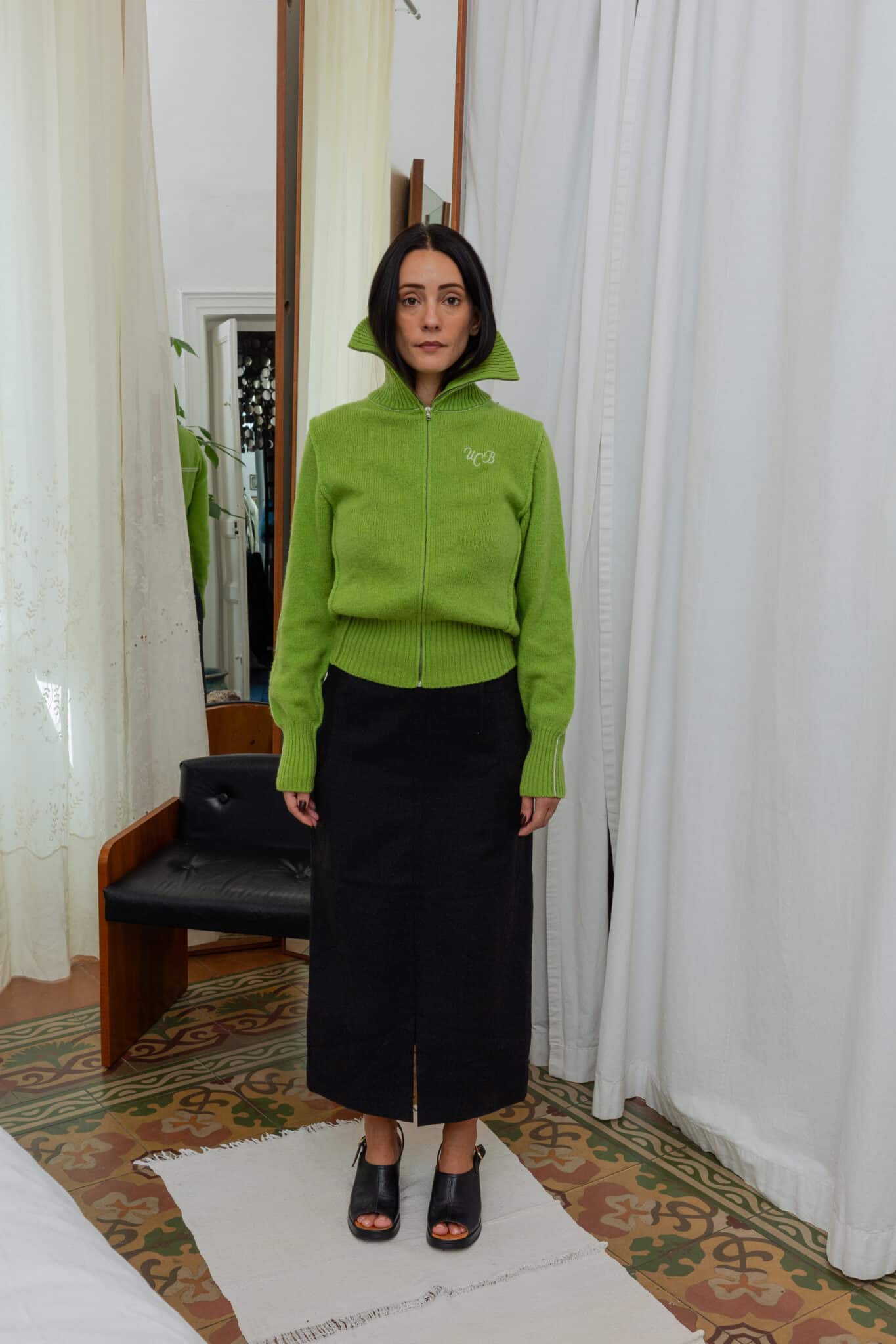 Full outfit featuring bright green wool zip sweater and black wool midi skirt.