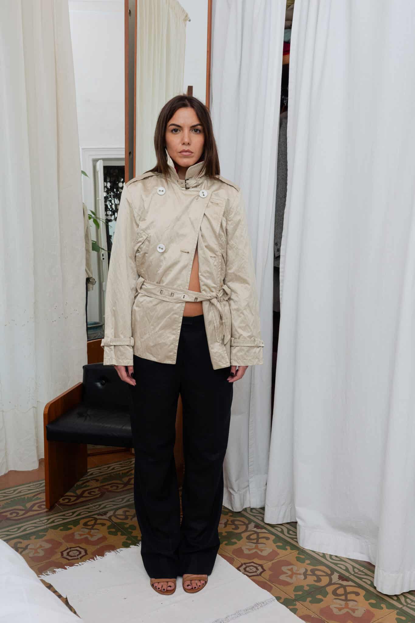 Beige cropped trench jacket with belt and front buttons.