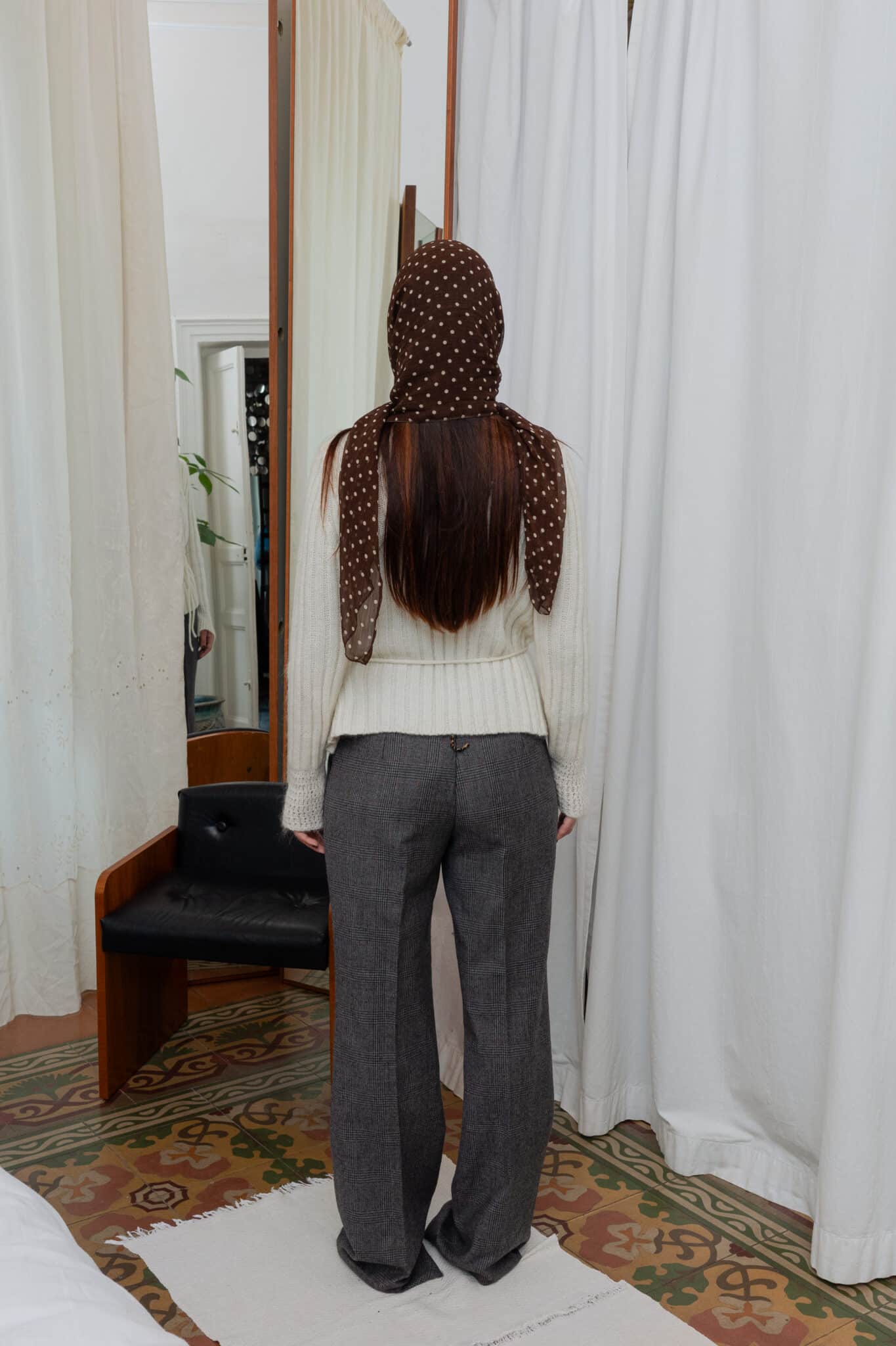 Brown polka dot scarf paired with cream knit and wool trousers.