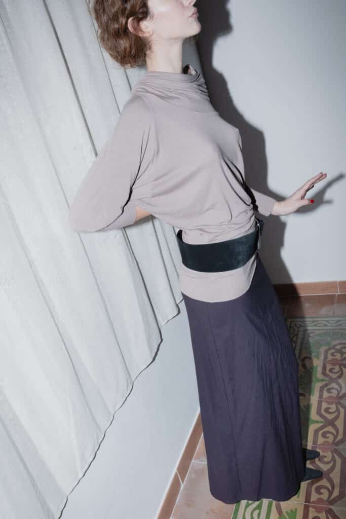 navy maxi skirt with a slim silhouette styled with a taupe blouse.