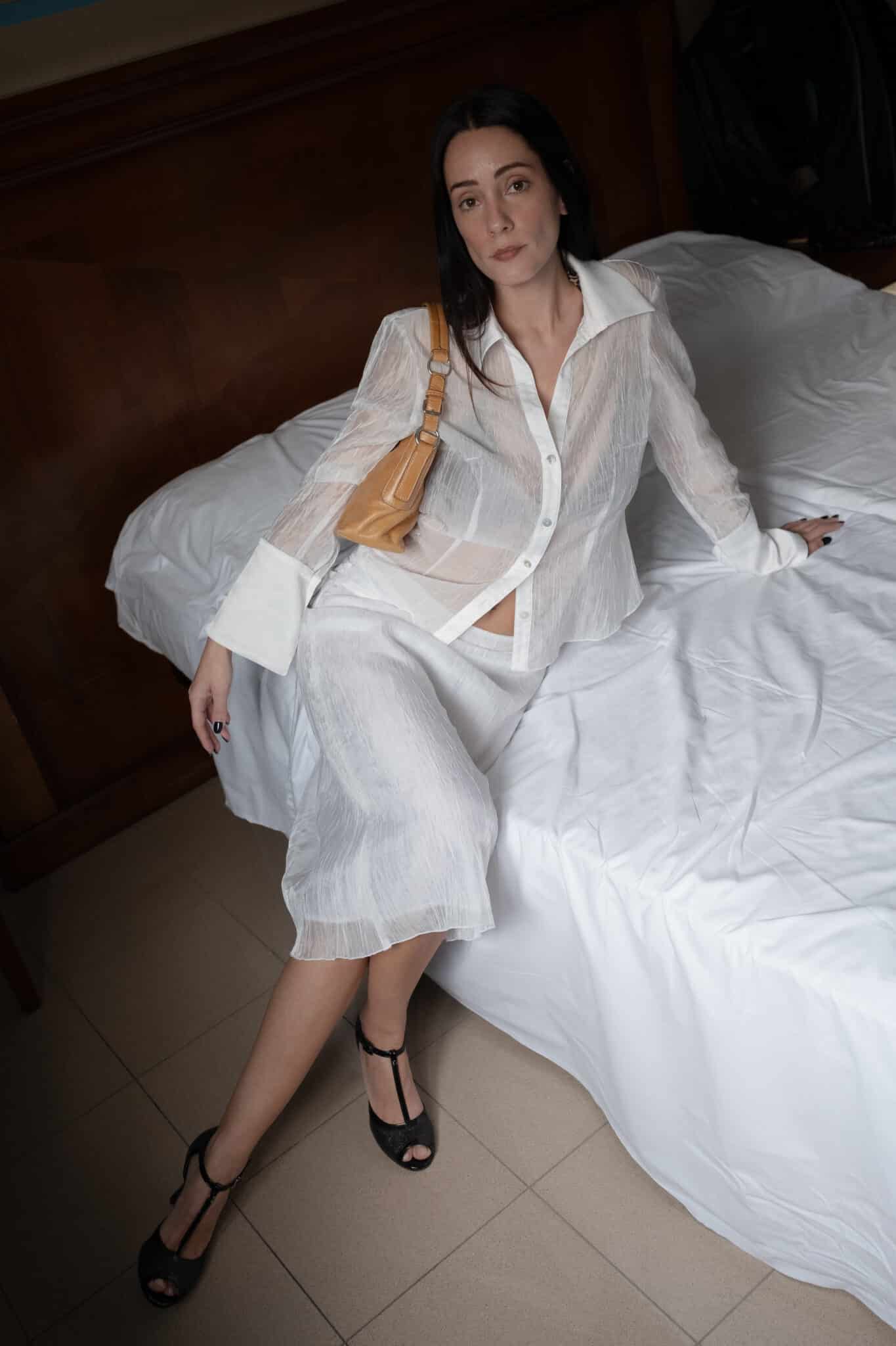 Coordinated white outfit featuring a sheer button-front shirt and straight midi skirt.