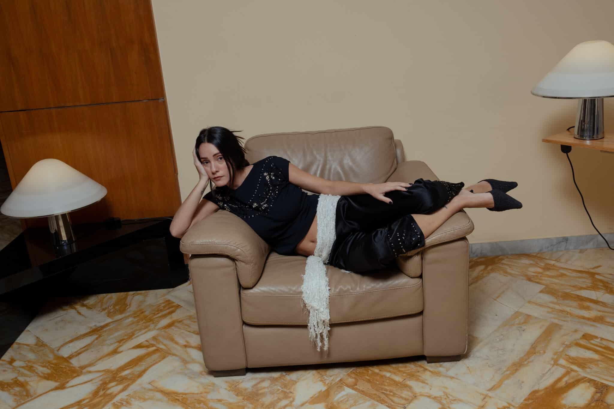 Black silk capri pants with cropped length and decorative embroidery worn with matching top