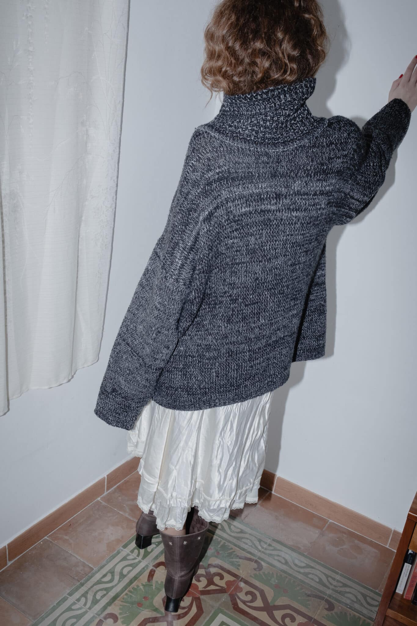 Layered styling of a silky midi skirt with a dark woolen sweater.