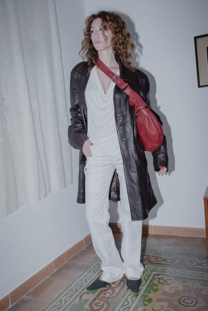 red stitched leather bag paired with an all-white draped and relaxed outfit