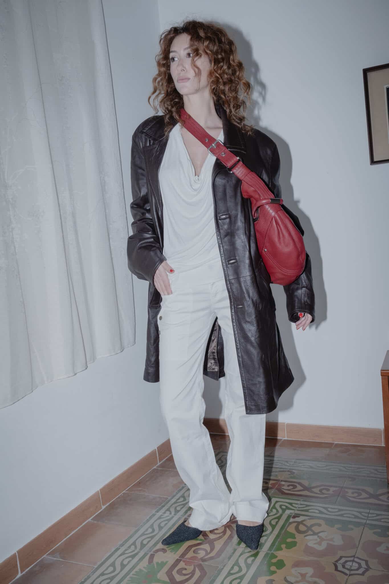 red stitched leather bag paired with an all-white draped and relaxed outfit