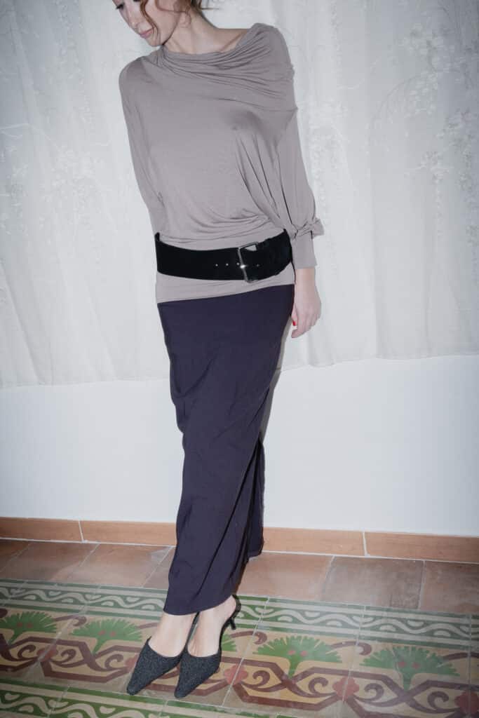 navy maxi skirt with a slim silhouette styled with a taupe blouse.
